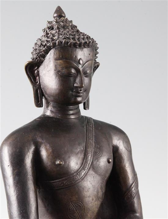 A large Tibetan bronze seated figure of Buddha Shakyamuni, probably 13th century, height 39.5cm, minor old repairs